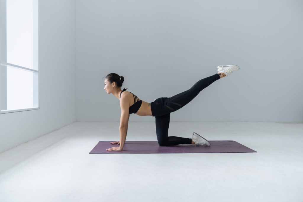Woman Performing Yoga Using a Grey Mat
