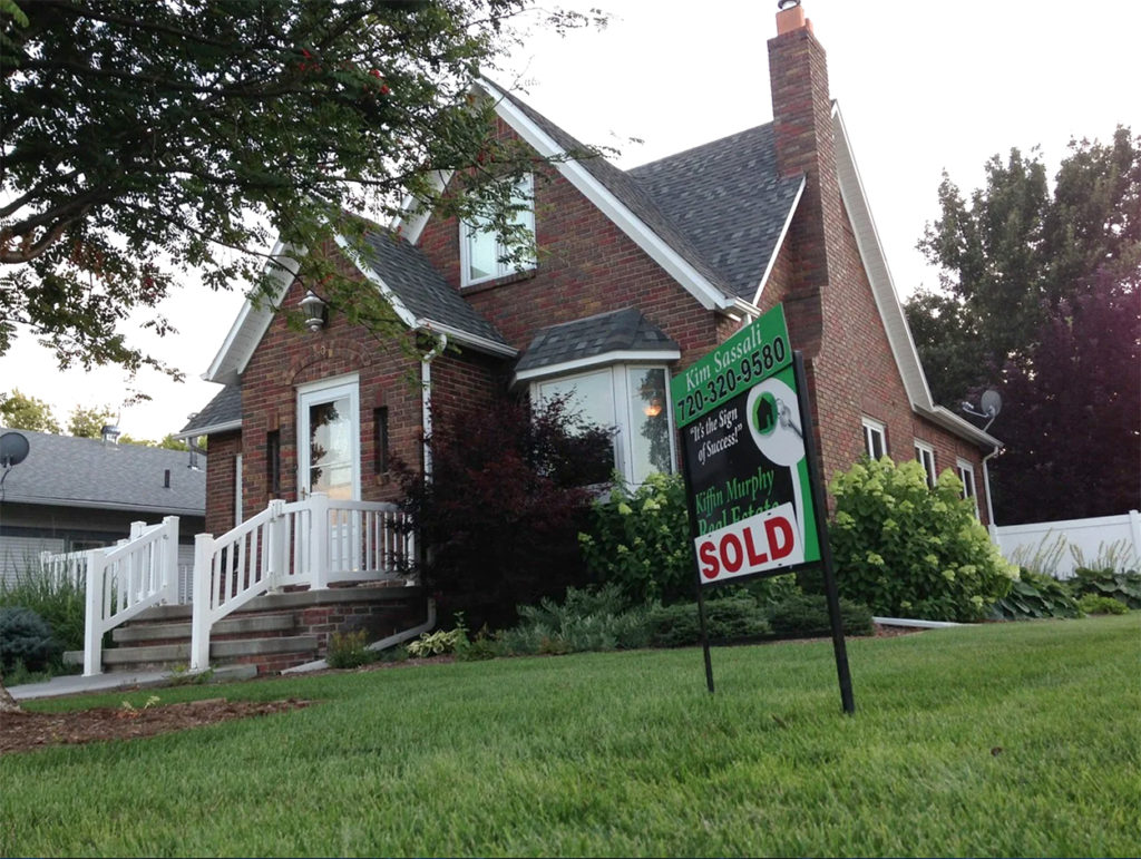 Brick home with a sold sign on the front lawn