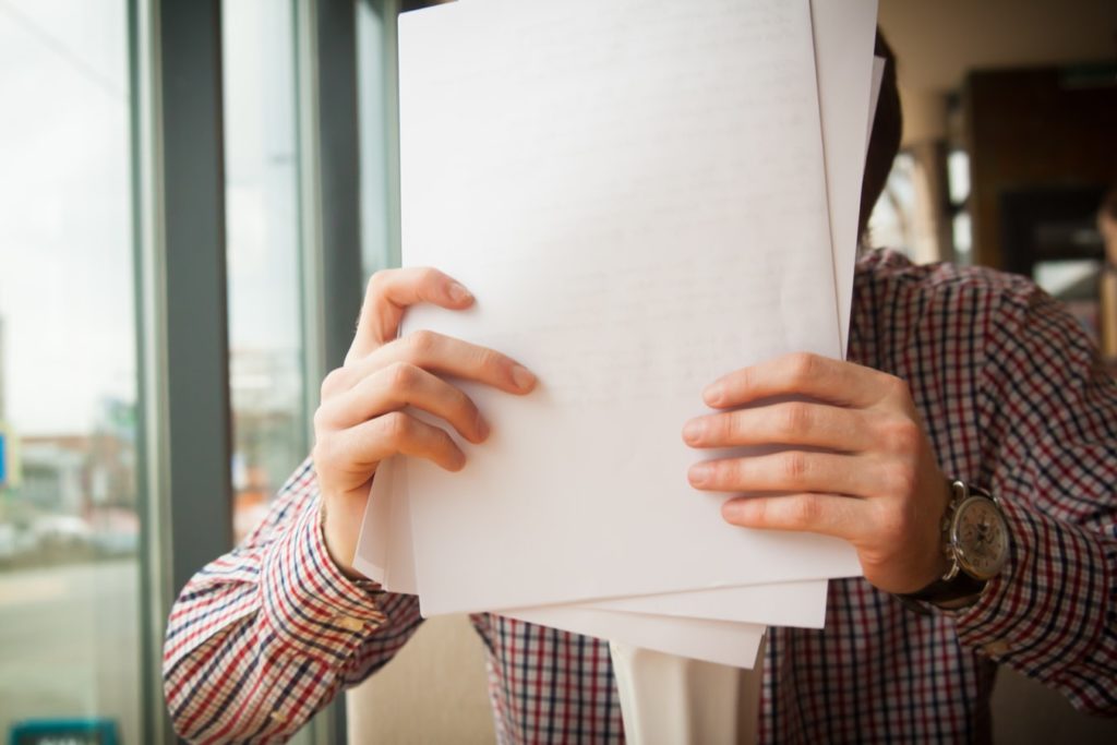 Person holding a stack of documents