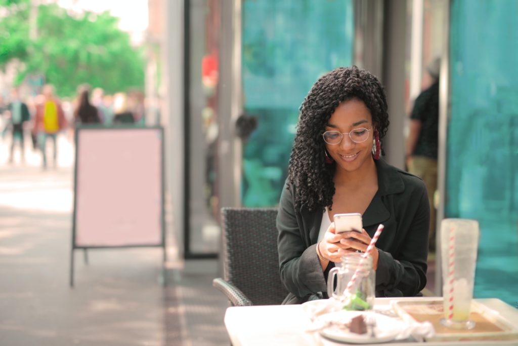 Woman eating outside, while checking her phone