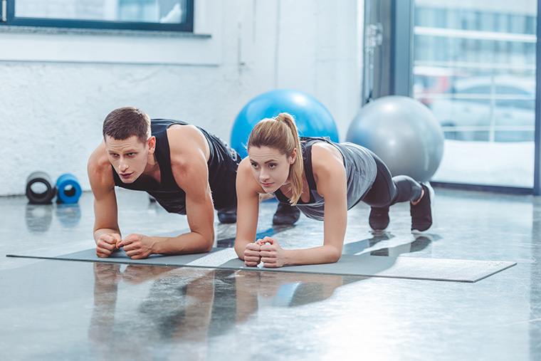 Couple holding plank while working out together.