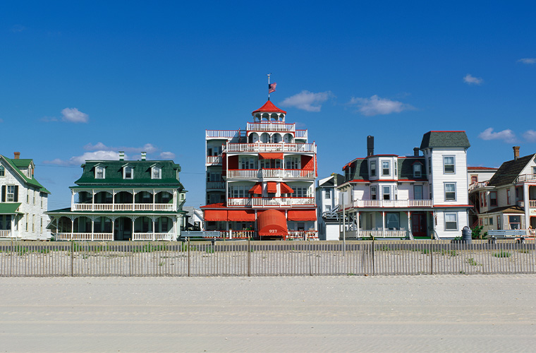 View from the beach showing Cape May Victorian style red and green roof top buildings.