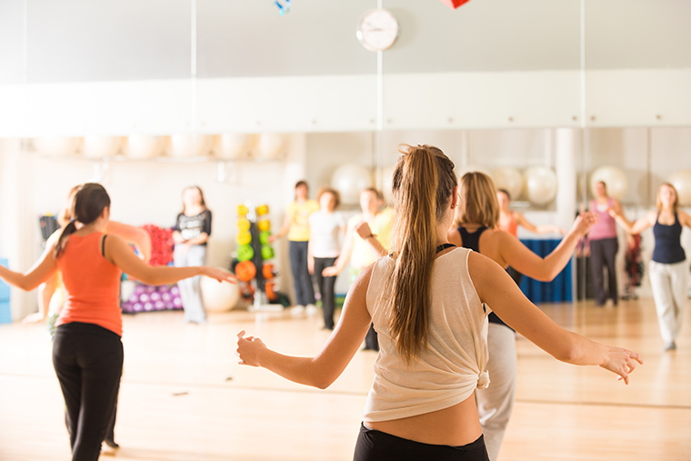 A group of women in a well-lit dance studio, engaged in the art of dance.