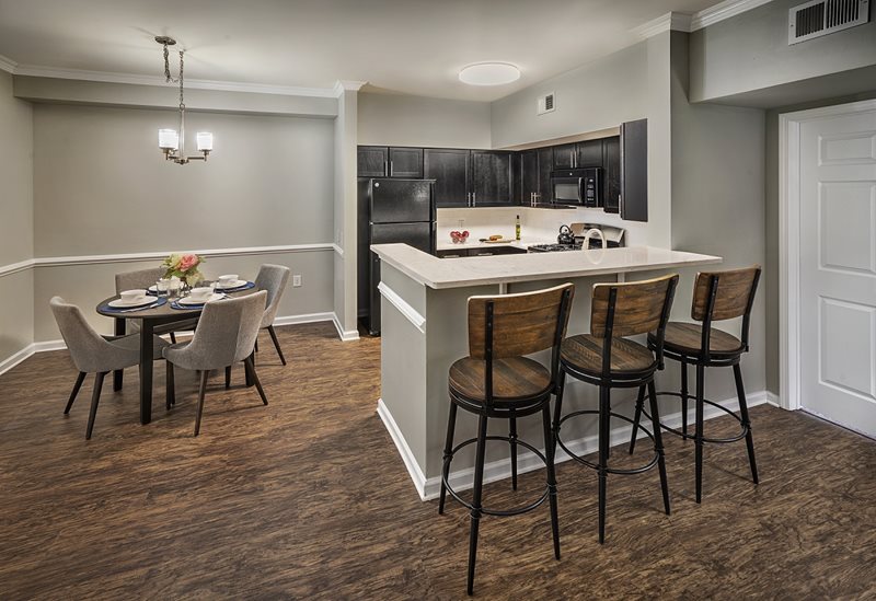 A spacious open floor plan at Windsor Woods Apartments in Princeton, NJ. The kitchen, bar, and dining room are seamlessly integrated, creating a welcoming and modern living space.