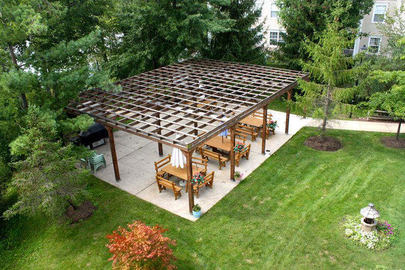 Beautiful Large Outdoor Community Pergola with multiple tables, chairs, and umbrellas at Lakeside Village.