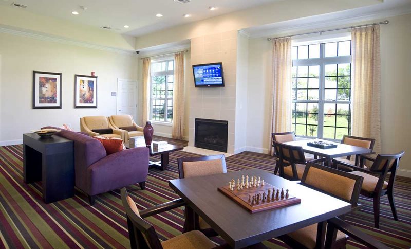 Cedar Manor's Club House with multiple seating areas, fireplace and TV