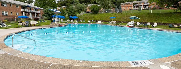 Community pool with chairs and umbrellas.